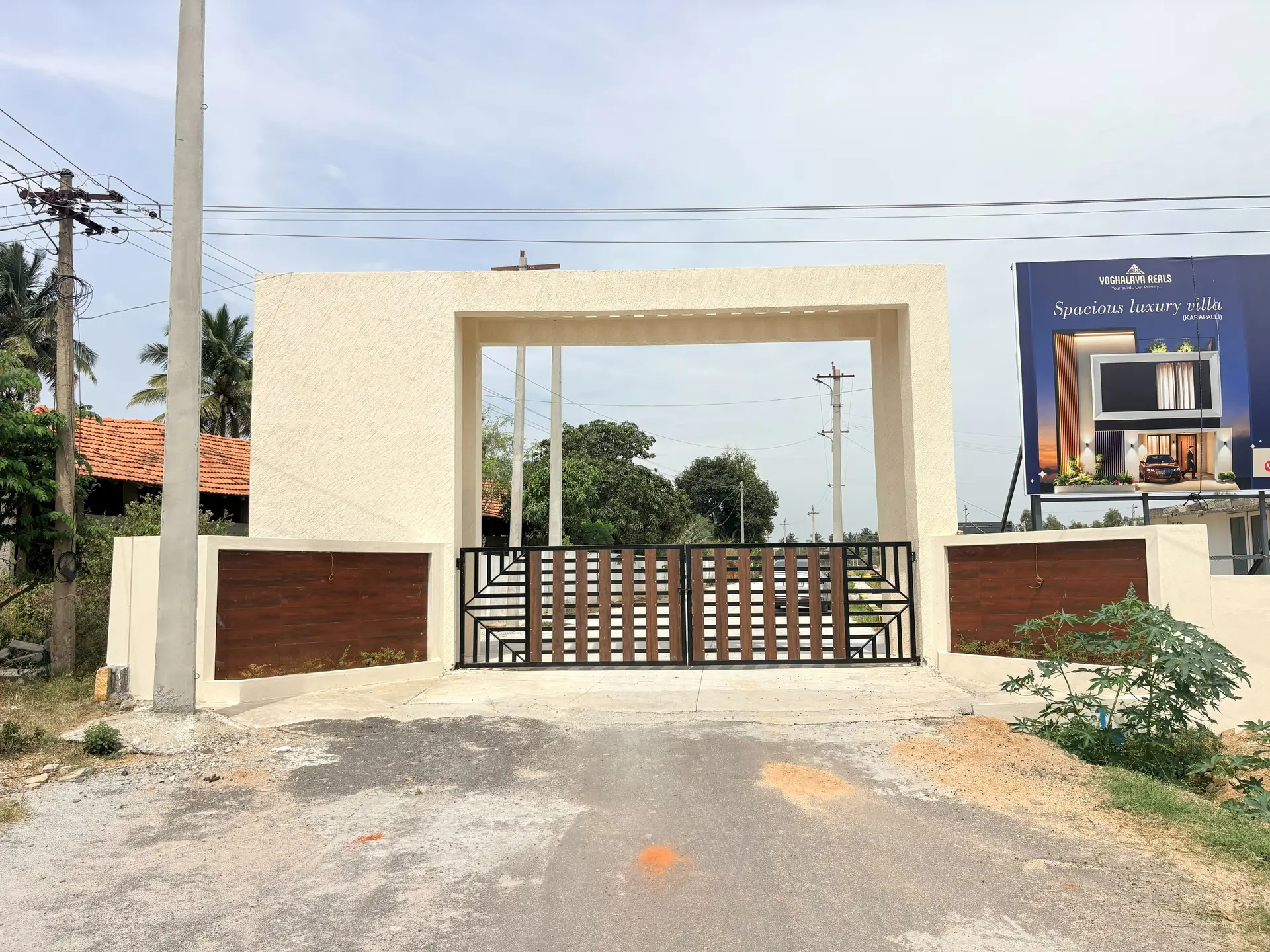 The finished entrance arch at Poes Garden with its gates closed, seen from the approach road.
